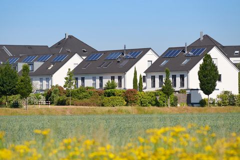 Einfamilienhäuser neben einem Rapsfeld