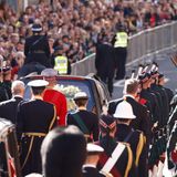 Prinz Andrew (links), Prinzessin Anne und König Charles III. schreiten hinter dem Auto mit dem Sarg ihrer Mutter her.
