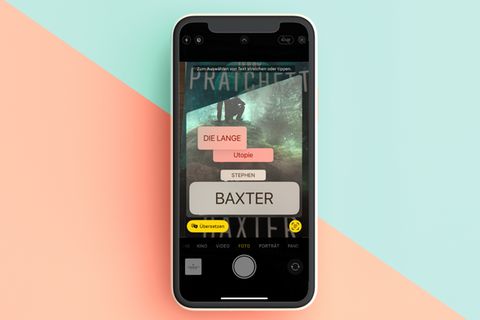 Per Kamera übersetzen  Was steht auf dem Schild? Diese Frage beantwortet das iPhone nun live – in der Kamera-App. Richten Sie die Knipse auf den gewünschten Text, wählen Sie unten links das Symbol zur Texterkennung aus. Das Feature ermöglicht es schon seit iOS 15, Text im Bild auszuwählen und zu kopieren. Nun lässt sie sich per Knopfdruck auch gleich übersetzen. Vorsicht: Ist die Schrift sehr kleinteilig, ist auch die Übersetzung schwerer zu entziffern.