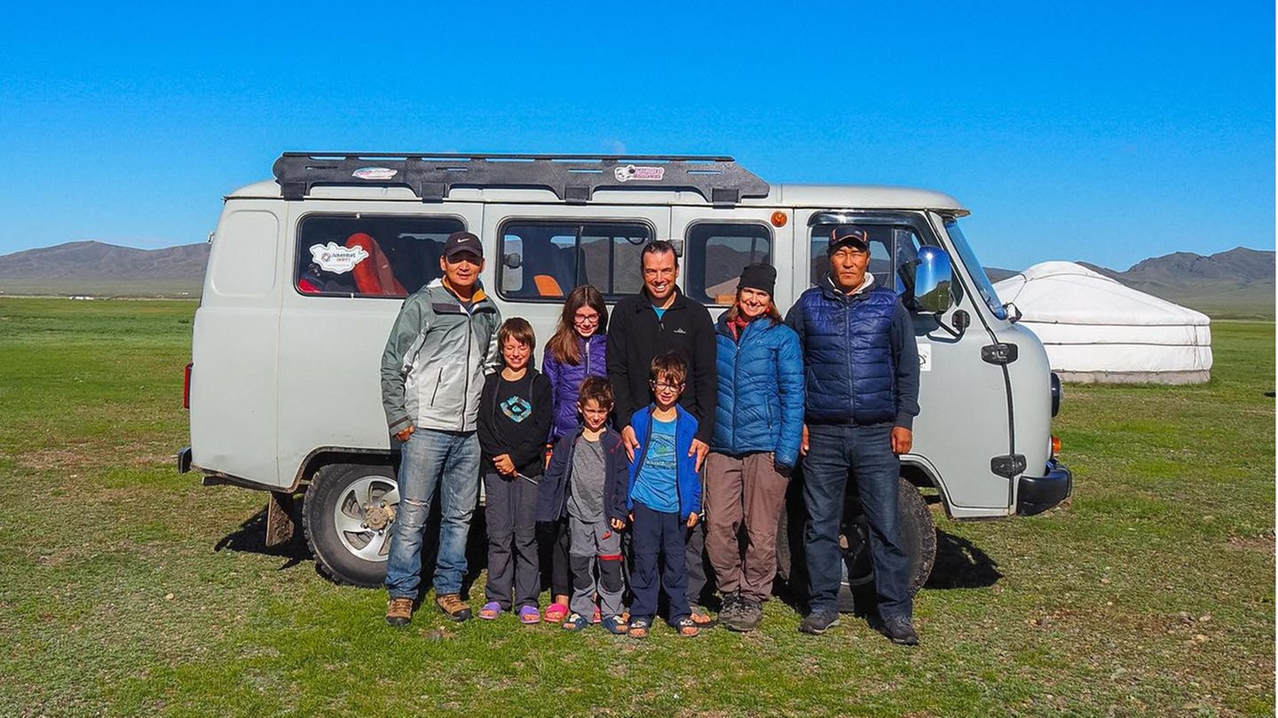 Die ganze Familie zusammen mit zwei Guides vor ihrem Gefährt, mit dem es quer durch die Mongolei geht