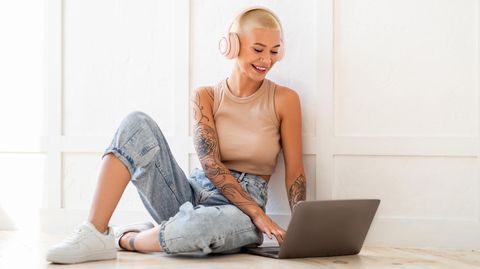 Eine junge Frau sitzt an ihrem Laptop