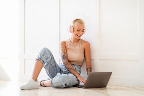 Eine junge Frau sitzt an ihrem Laptop