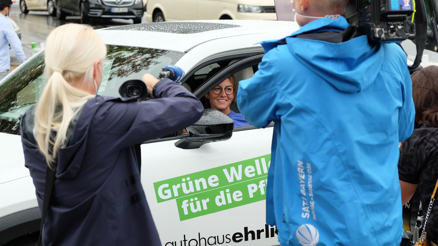 Eine Pflegekraft sitzt in einem neuen Dienstwagen