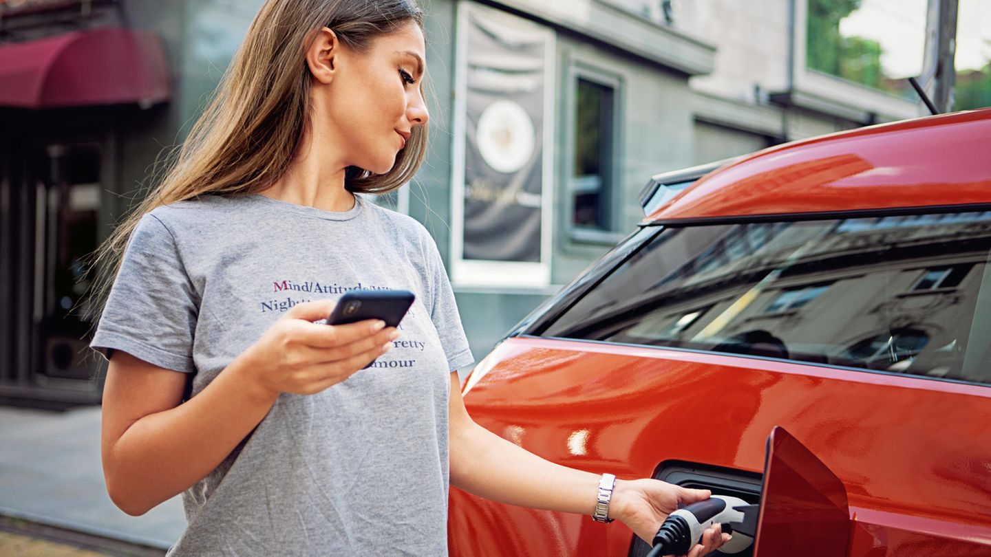 Eine Frau lädt ein Elektroauto auf