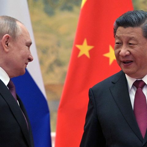 Xi Jinping und Putin sprechen vor russischer und chinesischer Flagge miteinander