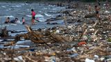 Omoa, Honduras. Menschen baden an einem Strand, der mit Plastikmüll übersäht ist. Die hondurianische Karibik wird regelmäßig mit Plastikabfällen aus Guatemala überschwemmt. Ähnlich sieht es im Nachbarland El Salvador aus: Der Strand am See Suchitlán ist mit bunten Überresten übersäht, die über die Nebenflüsse angespült werden.