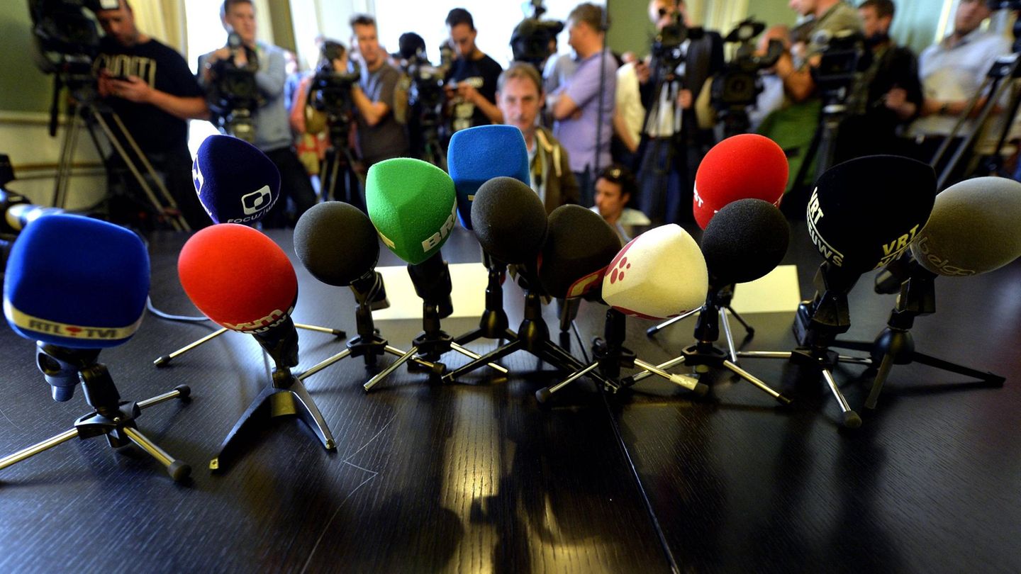 Mikrophone von Journalistinnen und Journalisten bei einer Pressekonferenz