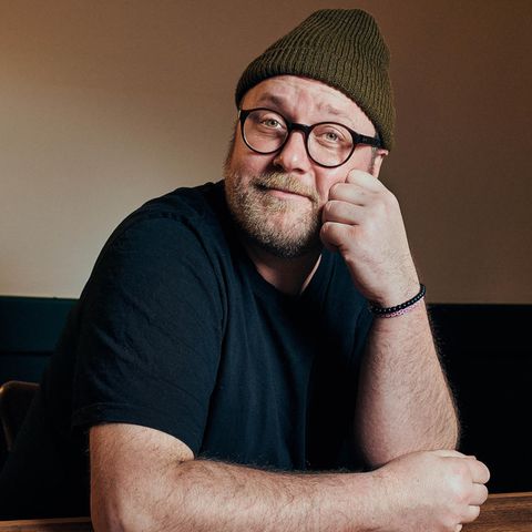 Max Strohe, an einem Tisch sitzend