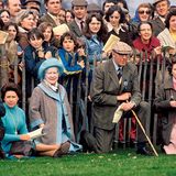 Da sitzen sie als Zuschauer des Pferderennens in Badminton im Gras fast wie normale Sterbliche: Margaret (in Türkis), Queen Mum und die Queen (in Rosa). Zwischen ihnen kniet der Herzog von Beaufort, dem das ganze Anwesen samt Rennbahn und Park gehört