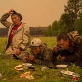 Freiwillige Feuerwehrleute machen am 1. Juli 2021 eine Essenspause in Magaras, Zentral-Sacha, Sibirien. Sacha, auch bekannt als Jakutien, das sich über mehr als drei Millionen Quadratkilometer im äußersten Nordosten der Russischen Föderation erstreckt, erlebte im Jahr 2021 verheerende Waldbrände, starke Rauchverschmutzung und das Auftauen des Permafrosts.