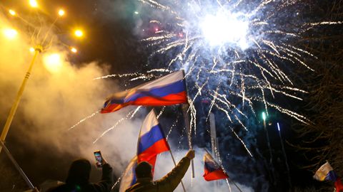 Im Februar 2022 schwenken Bewohner russische Nationalflaggen und feiern die Anerkennung der Separatistengebiete