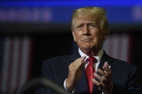 Donald Trump applaudiert vor US-Flaggen