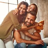 Eine Frau, ein Mann und ein Kind nehmen sich innig in den Arm.