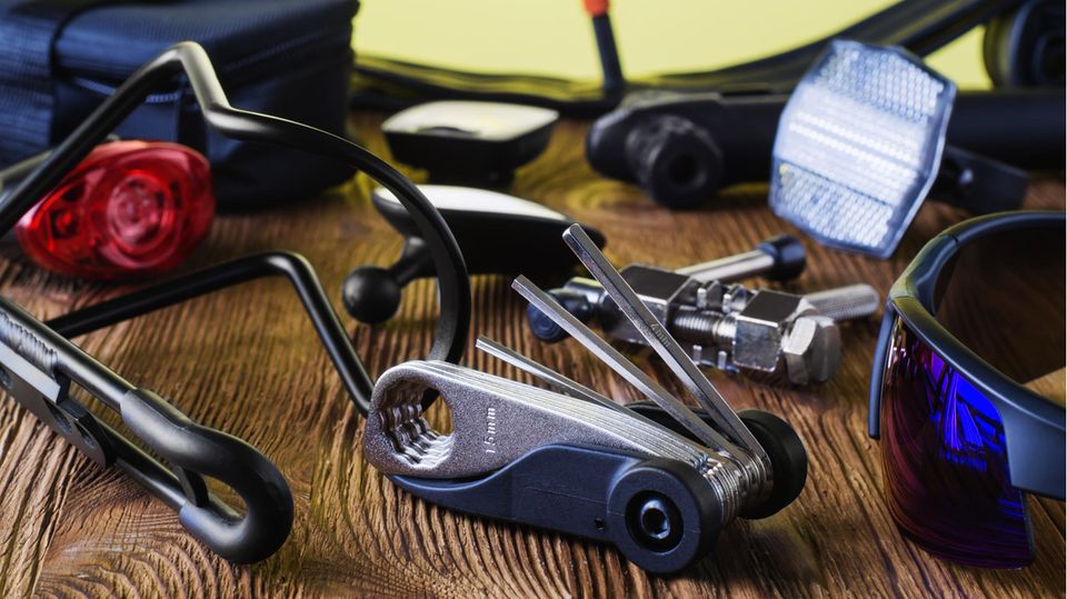 Multitool fürs Bike: Werkzeug und Fahrradzubehör liegt auf einem Holztisch