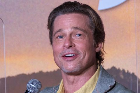 Brad Pitt mit einem Mikrofon in der Hand