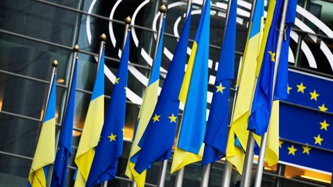 Je fünf Flaggen der Ukraine und der EU hängen abwechselnd an Flaggenmasten in einer Reihe