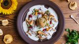 Wiesn-Semmelknödel mit Rahmschwammerl  In Bayern sind wir "narrisch", also verrückt nach Knödeln. Tipp gleich für den Anfang: Sollte die Zeit für das Knödel-Zubereiten nicht reichen, passen dazu auch bayrische Tagliatelle.      Zutaten für 4 Personen  Vorbereitungszeit 20 Minuten  Zubereitungszeit 20 Minuten      Semmelknödel:  300 g Semmeln (Brötchen/Baguette)  1 Stück Schalotte (oder gelbe Zwiebel 37 g)  20 g Butter 150 ml Milch 1/2 TL Salz  6 Prisen Pfeffer schwarz 6 Prisen geriebene Muskatnuss  2 Stück Eier (Größe M – 104 g) 1 EL fein geschnitten Petersilie  Salz für das Kochwasser      Rahmschwammerl:  250 g Pfifferlinge  1 Stück Zwiebel oder zwei Schalotten  1 TL Sonnenblumenöl  300 ml Sahne  1 TL Speisestärke  300 ml Gemüsebrühe  etwas Zitronenabrieb  5 Prisen Salz  5 Prisen Pfeffer  4 Prisen Muskat  2 Prisen Zucker  50 g kalte Butter      Butterbrösel:  80 g Butter  2 EL Semmelbrösel      Dekoration:  4 EL Preiselbeeren  1 TL Petersilie      Zubereiten:  Knödel zubereiten:  Die Semmeln in 0,5 cm große Würfel schneiden und in einer Schüssel bereit stellen.  Die Schalotte halbieren, schälen, in feinste Würfel schneiden und mit 20 g Butter farblos 5 Minuten glasig schwitzen.  Die Zwiebelwürfel mit der Milch aufgießen und aufkochen. Die Milch mit Salz, Pfeffer und Muskat abschmecken und über die Semmelwürfel gießen.  Die Semmelmasse vorsichtig verrühren und lauwarm abkühlen lassen.  Die Eier aufschlagen und zur Semmelmasse geben, fein geschnittene Petersilie dazu geben und vermischen.  Einen Topf mit Wasser aufstellen und bei Unsicherheiten einen Probekloss zubereiten. 50 g Knödelmasse formen und in das kochende Salzwasser einlegen. Den Knödel schwach wallend 12-14 Minuten ziehen lassen. Dann die Konsistenz überprüfen. Optional können Sie die Knödelmasse mit wenig Semmelbrösel fester gestalten.  Die Knödelmasse mit dem Eisportionierer portionieren und mit befeuchteten Händen runde Knödel drehen. Die Knödel zum Kochen bereit stellen.  Die Teller bei 80°C im Backofen warm stellen.      Rahmschwammerl zubereiten:  Die Pfifferlinge bei leichter Verschmutzung mit Pinsel und kleinem Messer putzen. Alternativ bei starker Verschmutzung: Vier Liter kaltes Wasser mit 2 EL Essig und 2 EL Mehl verrühren. Die Pilze flink im Mehlwasser waschen, kurz unter fließendem kalten Wasser abspülen und in der Salatschleuder trocken schleudern.  Die Pilze halbieren oder je nach Größe mundgerecht adrett vorbereiten und in einem Topf bei hoher Hitze mit dem Sonnenblumenöl anbraten.  Die Zwiebel oder Schalotten halbieren, schälen und in feine Würfel schneiden.  Etwa 4 EL Pilze für die Dekoration entnehmen und auf einem Teller bereit stellen.  Zwiebel zu den Pilzen in den Topf geben und 2 Minuten bei reduzierter Hitze anschwitzen.  Die Pilze im Topf mit der Gemüsebrühe ablöschen und aufkochen.  Die Knödel in das kochende Wasser einlegen und schwach wallend 12-14 Minuten ziehen lassen.  Die Speisestärke in die kalte Sahne geben und verrühren oder in einem Becher schütteln.  Die vorbereitete Sahne langsam zu den Pilzen gießen, die Soße dabei aufkochen.  Die Schwammerl-Sauce mit etwas Zitronenabrieb, Salz, Pfeffer, Muskat und Zucker abschmecken.    Butter in einem Topf schmelzen, die Butterbrösel zugeben und leicht Farbe nehmen lassen. Herdplatte ausschalten und mit Salz würzen.      Anrichten:  Mit einer Schaumkelle die gesamte Schwammerl und Zwiebeln auf heiße Teller anrichten.  Knödel aus dem Wasser heben und auf Küchenkrepp abtropfen lassen.  Knödel zu den Schwammerln setzen.  Die verbliebene Soße mit kalter Butter schaumig aufmixen und auf den Tellern anrichten.  Beiseite gestellte Pilze als Dekoration schön dazu richten.  Die Preiselbeeren im Pilzschaum anrichten.  Die Butterbrösel über die Knödel gießen und mit frisch geschnittener Petersilie vollendet servierenn      Tipp von Koch Thomas Sixt:  Das Waschen der Schwammerl ist fast so umstritten wie Öl im Kochwasser für Nudeln. Ich halte es praktisch und pragmatisch: Sind die Schwammerl zu schmutzig oder soll es schnell gehen, dürfen diese bei mir einen flinken Freischwimmer machen. Wer das schnell macht, wird keinen merklichen Geschmacksverlust bemerken. Warum kommt Mehl und Essig (Säure) ins Wasser? Die Säure verändert den PH-Wert vom Wasser und das Mehl bindet den Schmutz. Ein Pilzgericht ohne Zähneknirschen ist so garantiert. Beim Knödel-Essen daran denken: Knödel schneidet man nicht sondernd zupft diese am Teller. Nur flaumige Knödelstückerl können die Soße gut aufnehmen.