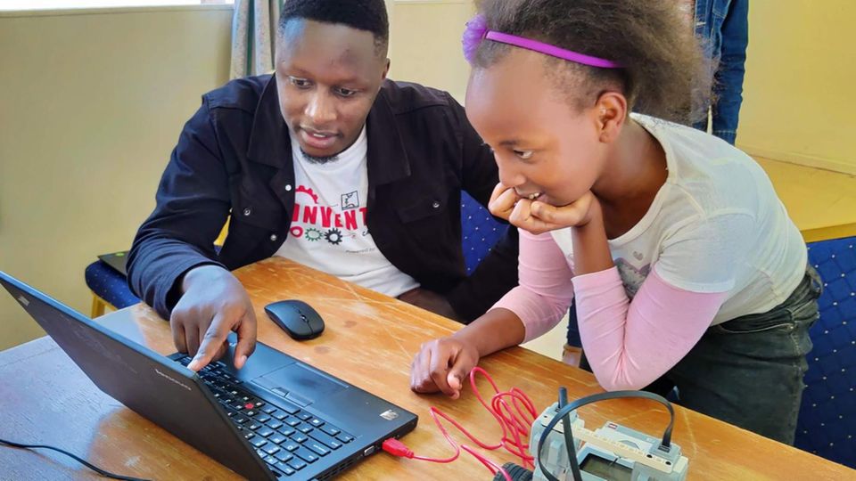 Update Kinakoni: Alex Magu, Gründer des STEM Impact Center Kenya, erklärt einer Schülerin die Software, um einen Roboter zu steuern Alex Magu, Gründer des STEM Impact Center Kenya, erklärt einer Schülerin die Software, um einen Roboter zu steuern