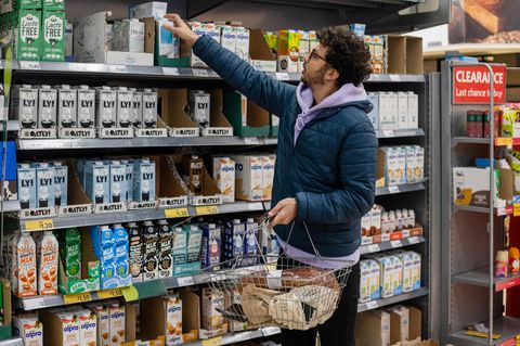 Mann im Supermarkt vor Pflanzendrinks