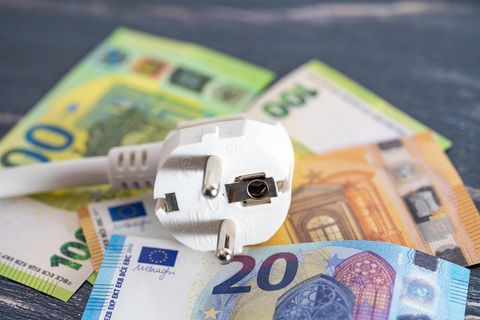Ein Stromstecker auf verschiedenen Euroscheinen