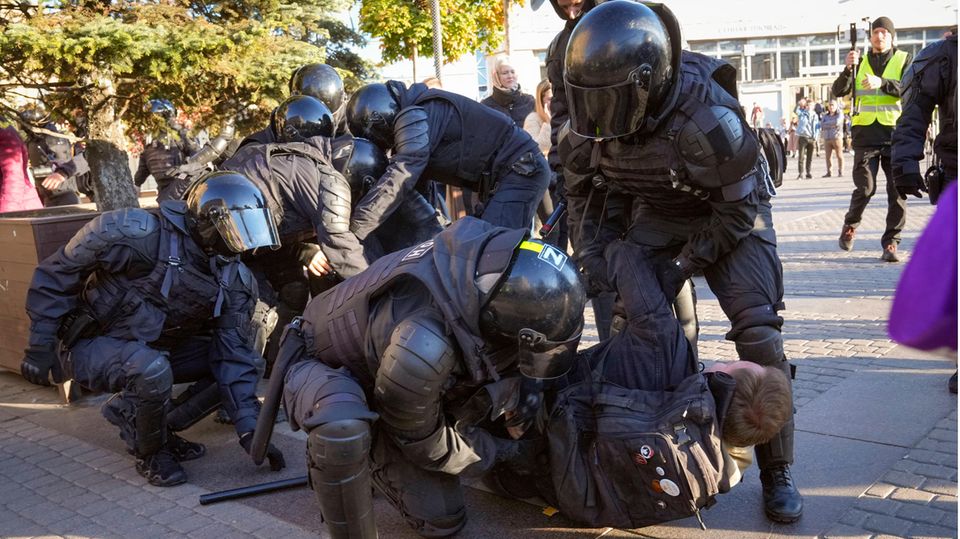 Russische Polizisten halten Demonstranten fest