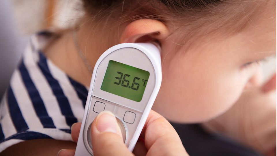Bei einem Kind wird mit einem Fieberthermometer die Temperatur gemessen.