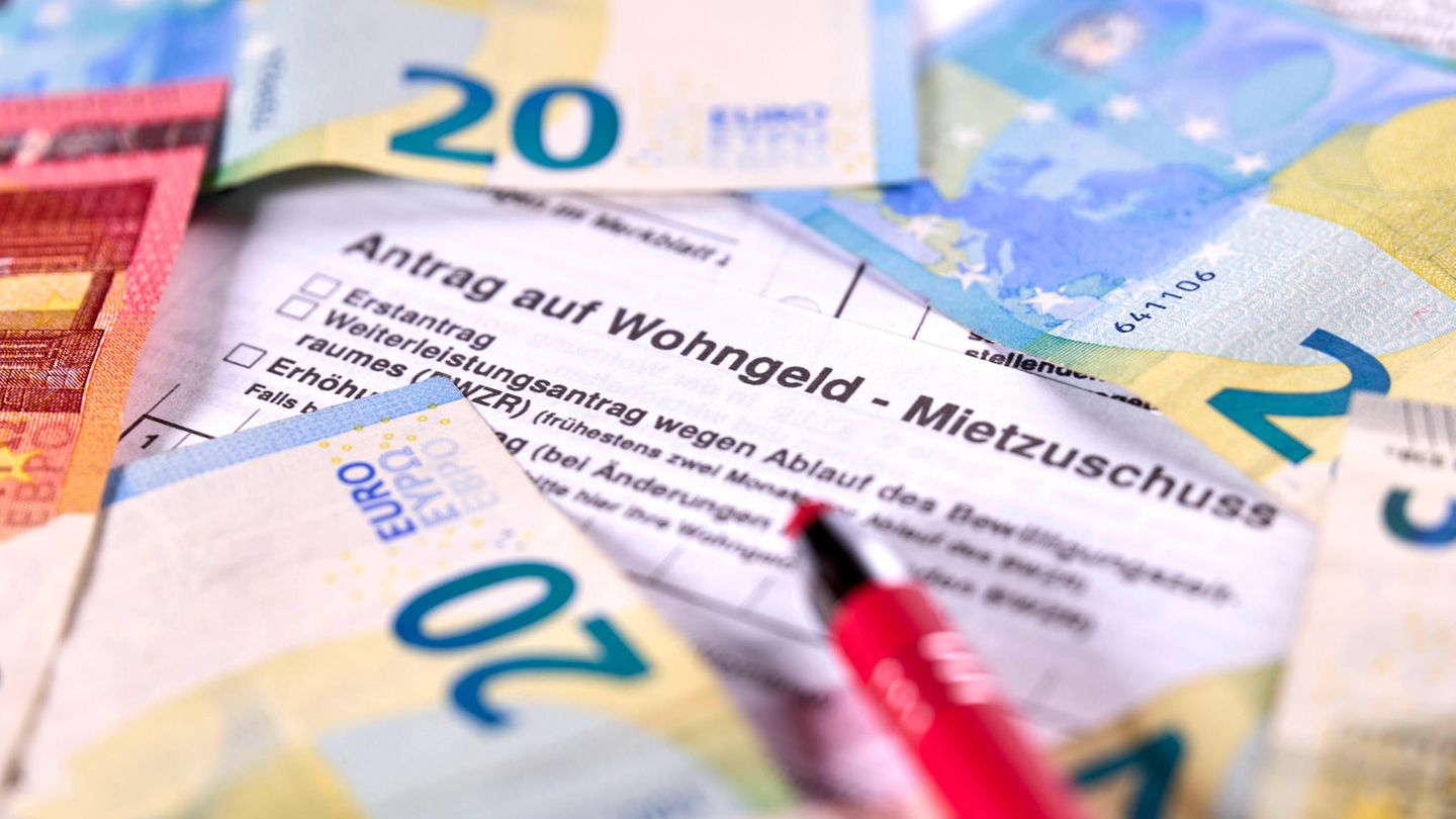 Ein Antrag auf Wohngeld liegt unter Geldscheinen und einem Stift