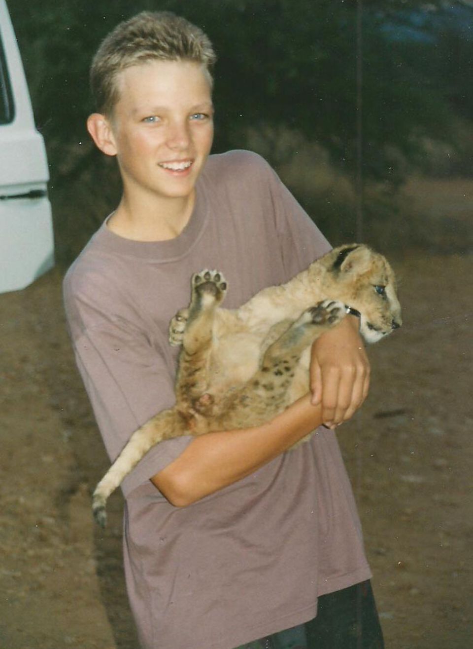 EES als Teenager mit einem Löwenbaby auf dem Arm