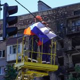 Arbeiter befestigen eine russische Flagge über einer Straße in Mariupol