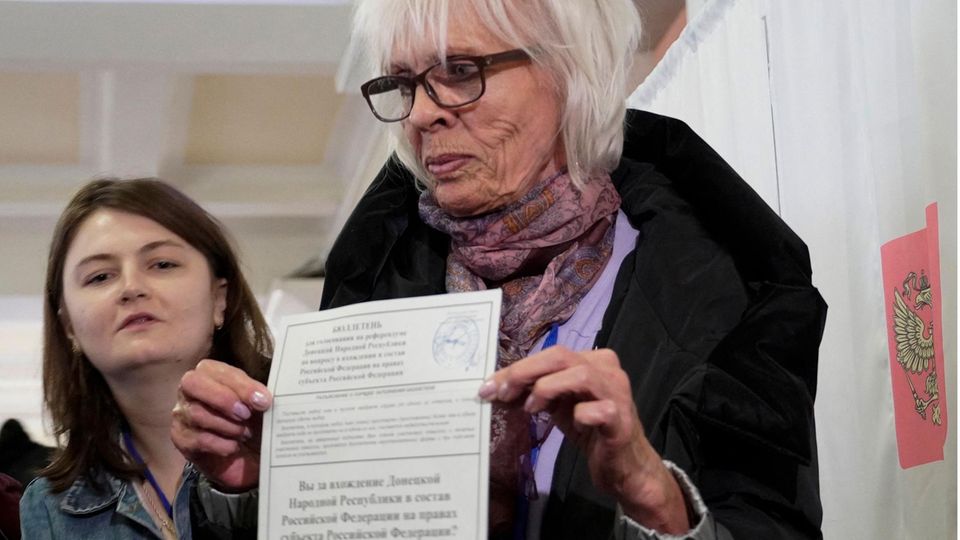 Eine aus der Ukraine geflohene Frau zeigt in Rostov am Don ihren Stimmzettel – selbstverständlich mit einem Kreuz bei "Ja". Unter Tränen erzählten Frauen, wie sie sich darauf freuten, bald in ihre Heimat zurückkehren zu können, weil sie dann durch Russlands Schutz keine ukrainischen Angriffe befürchten müssten. Die Ukraine sprach dagegen von einer "Propagandashow" des Kreml. "Heute gibt es in den besetzten Gebieten keinen juristischen Vorgang, der "Referendum" genannt werden kann", sagte der Berater des Präsidentenbüros, Mychajlo Podoljak, am Freitag.