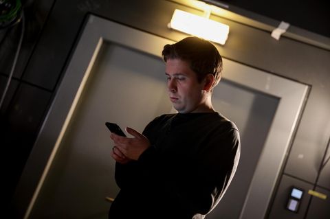 Kevin Kühnert schaut auf sein Smartphone