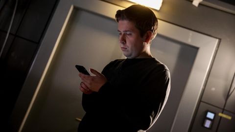 Kevin Kühnert schaut auf sein Smartphone