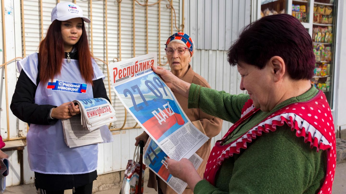 Eine Freiwillige der regionalen Wahlkommission von Luhansk verteilt vor dem Scheinreferendum Zeitungen an die Bürger in Luhansk