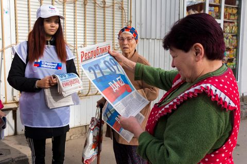 Eine Freiwillige der regionalen Wahlkommission von Luhansk verteilt vor dem Scheinreferendum Zeitungen an die Bürger in Luhansk