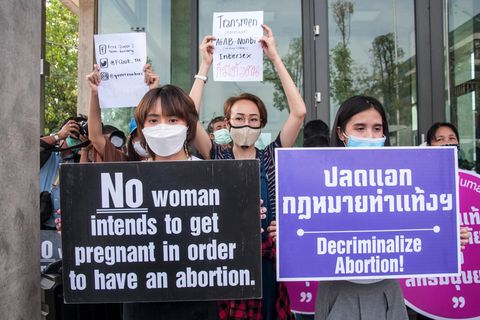 Demonstrierende einer Frauenrechtsgruppe in Thailand halten Schilder hoch