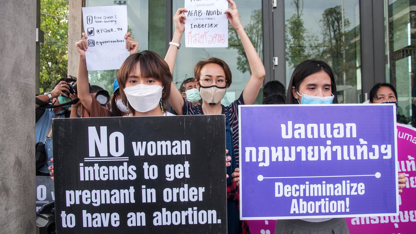 Demonstrierende einer Frauenrechtsgruppe in Thailand halten Schilder hoch