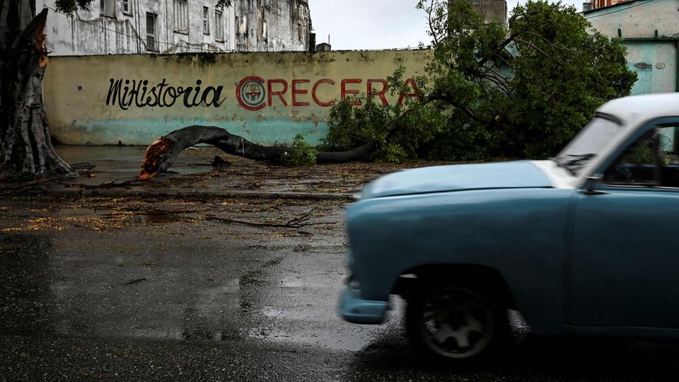 In Havana, Kuba fährt ein Auto an einem durch "Ian" umgestürzten Baum vorbei. In der besonders betroffenen Provinz Pinar del Río seien zwei Menschen nach dem Einsturz ihrer Häuser gestorben, teilt die Regierung am Dienstag mit.