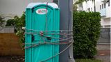 Damit diese mobile Toilette in Miami nicht zu mobil wird, hat jemand sie mit einem Seil an einen Betonpfosten gebunden