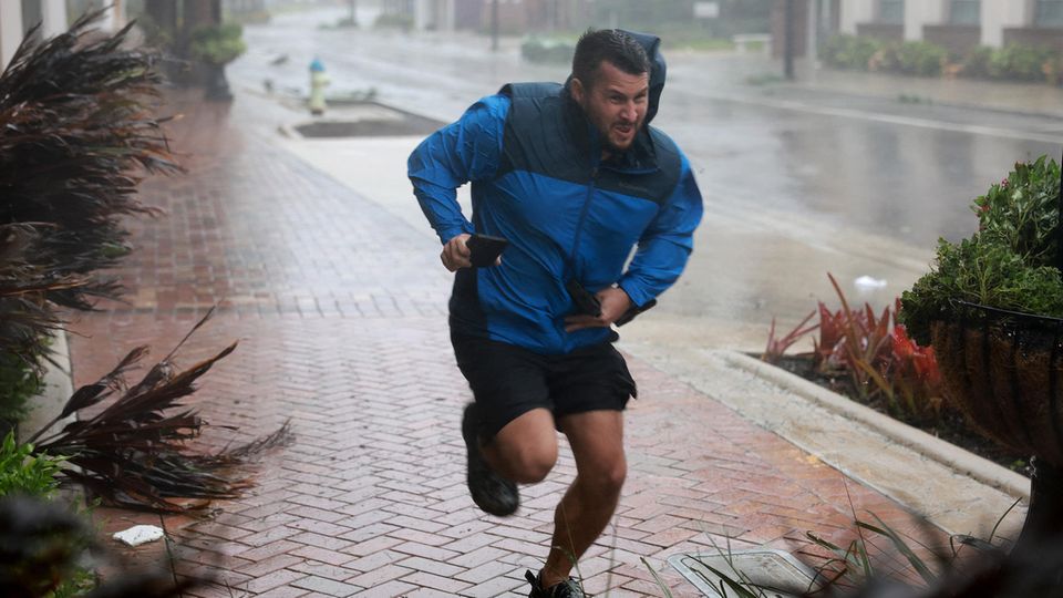 Brent Shaynore hat in Sarasota sichtlich Mühe, durch Regen und Wind einen vor Hurrikan "Ian" geschützten Ort zu erreichen