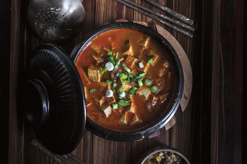 Scharfer Doenjang Chigae (Eintopf mit fermentierter Sojabohnenpaste)      Zutaten:  1 EL Sesamöl  1 EL Gochugaru (Chiliflocken)  1⁄4 Zwiebel, fein gewürfelt  3 Knoblauchzehen, fein gehackt  1 kleine Kartoffel, geschält und gewürfelt  80 g Zucchini, gewürfelt  Salz  1⁄2 TL schwarzer Pfeffer aus der Mühle  3 EL Doenjang (Sojabohnenpaste)  1 EL helle Sojasauce  500 ml Gemüsebrühe  500 g mittelfester oder fester Tofu, in mundgerechte Würfel geschnitten  2 Frühlingszwiebeln, gehackt  1 Jalapeño, geputzt und in dünne Streifen geschnitten      Zubereitung:  1. Das Sesamöl bei mittlerer Hitze in einem mittelgroßen Ddukbaegi oder Schmortopf erhitzen. Sofort das Gochugaru hinzufügen und mit einem Kochlöffel zu rühren beginnen. Darauf achten, dass das Gochu- garu nicht verbrennt (dunkel wird), da es sonst bitter schmeckt.  2. Sobald das Gochugaru zu blubbern und schäumen beginnt, Zwie- beln, Knoblauch, Kartoffeln, Zucchini, 1 TL Salz und Pfeffer hinzufügen. Alles etwa 1 Minute garen, bis die Zutaten ihr Aroma entfalten.  3. Doenjang hinzufügen und rühren, bis das Gemüse gleichmäßig damit überzogen ist. Dann das Ganze mit Sojasauce ablöschen und die Gemüsebrühe angießen. Den Tofu hinzufügen und den Eintopf zum Kochen bringen. Dann die Hitze reduzieren und den Eintopf etwa 20 Minuten köcheln lassen, bis die Kartoffeln schön zart sind.  4. Schließlich die Frühlingszwiebeln und die Jalapeño hinzufügen und vor dem Servieren weitere 2 Minuten garen