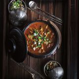 Scharfer Doenjang Chigae (Eintopf mit fermentierter Sojabohnenpaste)      Zutaten:  1 EL Sesamöl  1 EL Gochugaru (Chiliflocken)  1⁄4 Zwiebel, fein gewürfelt  3 Knoblauchzehen, fein gehackt  1 kleine Kartoffel, geschält und gewürfelt  80 g Zucchini, gewürfelt  Salz  1⁄2 TL schwarzer Pfeffer aus der Mühle  3 EL Doenjang (Sojabohnenpaste)  1 EL helle Sojasauce  500 ml Gemüsebrühe  500 g mittelfester oder fester Tofu, in mundgerechte Würfel geschnitten  2 Frühlingszwiebeln, gehackt  1 Jalapeño, geputzt und in dünne Streifen geschnitten      Zubereitung:  1. Das Sesamöl bei mittlerer Hitze in einem mittelgroßen Ddukbaegi oder Schmortopf erhitzen. Sofort das Gochugaru hinzufügen und mit einem Kochlöffel zu rühren beginnen. Darauf achten, dass das Gochu- garu nicht verbrennt (dunkel wird), da es sonst bitter schmeckt.  2. Sobald das Gochugaru zu blubbern und schäumen beginnt, Zwie- beln, Knoblauch, Kartoffeln, Zucchini, 1 TL Salz und Pfeffer hinzufügen. Alles etwa 1 Minute garen, bis die Zutaten ihr Aroma entfalten.  3. Doenjang hinzufügen und rühren, bis das Gemüse gleichmäßig damit überzogen ist. Dann das Ganze mit Sojasauce ablöschen und die Gemüsebrühe angießen. Den Tofu hinzufügen und den Eintopf zum Kochen bringen. Dann die Hitze reduzieren und den Eintopf etwa 20 Minuten köcheln lassen, bis die Kartoffeln schön zart sind.  4. Schließlich die Frühlingszwiebeln und die Jalapeño hinzufügen und vor dem Servieren weitere 2 Minuten garen