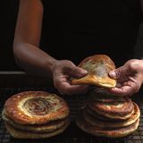 Süße Hotteok (Gebratene, gefüllte Pfannkuchen)      Zutaten:  2 1⁄4 TL Trockenhefe  1 TL Zucker  315 g Universalmehl  75 g süßes Klebreismehl  Salz  1 EL Olivenöl  310 ml lauwarmer Pflanzendrink  30 g Pistazienkerne  35 g Pinienkerne  30 g Pekannusskerne  2 EL Rohrohrzucker  1 EL Sesam  2 TL gemahlener Zimt  1 TL Maisstärke  Öl zum Frittieren      Zubereitung:  1. In einer kleinen Schüssel Hefe, Zucker und 60 ml lauwarmes Wasser verrühren. Etwa 10 Minuten beiseitestellen, bis die Mischung zu schäumen beginnt.  2. In einer großen Schüssel Mehl, Reismehl, 1 TL Salz und Öl vermengen. Die Hefemischung hinzufügen und den Pflanzendrink dazugießen. Mit einem Kochlöffel verrühren, bis ein Teig entsteht.  3. Die Hände leicht mit Öl benetzen und den Teig etwa 5 Minuten kneten. Der Teig ist sehr klebrig, aber wenn sich gar nicht damit arbeiten lässt, noch etwas Mehl hinzufügen. Den Teig mit den Händen zu einer unschönen Kugel formen.  4. Dann die Teigkugel in eine eingefettete Schüssel legen. Die Schüssel mit Frischhaltefolie oder einem Deckel abdecken und an einem warmen Ort etwa 1 Stunde gehen lassen, bis der Teig sein Volumen verdoppelt hat. Den Teig danach behutsam nach unten drücken, um das Gas entweichen zu lassen, und in der abgedeckten Schüssel weitere 20–30 Minuten gehen lassen, bis er sein Volumen erneut verdoppelt hat  5. Pistazien, Pinienkerne und Pekannüsse hacken (man kann sie auch kurz in einem Standmixer mixen) und in eine kleine Schüssel geben. Braunen Zucker, Sesam, Zimt, Maisstärke und 2 EL Wasser hinzufügen und alles vermengen. Die Nussfüllung beiseitestellen.  6. Ist der Teig ein zweites Mal aufgegangen, in 10 gleich große Portionen teilen. Jeweils mit einer Portion arbeiten und die restlichen Stücke in der mit Frischhaltefolie oder einem Deckel abgedeckten Schüssel lassen.  7. Die Teigportion zu einer kleinen Kugel formen, dann mit dem Hand- ballen oder einem Nudelholz zu einem flachen Fladen drücken. Sobald der Fladen etwas größer als Ihre Handfläche ist, den Teig auf eine Hand legen und 1 EL Nussmasse in die Mitte setzen. Die Teigränder nach oben und über die Füllung klappen, in der Mitte zusammendrücken und so die Füllung einschließen. Die kleine Tasche zwischen den Händen zu einer Kugel rollen. Dann beiseitestellen und mit einem Küchentuch abdecken. Mit den restlichen Teigportionen und der Nussfüllung wiederholen.  8. Das Pflanzenöl 1 cm hoch in eine große beschichtete Pfanne gießen. Das Öl bei mittlerer Hitze erhitzen, bis es schön heiß ist (wenn es brutzelt, sobald man ein winziges Stück Teig hineinlegt, kann es losgehen).  9. Jeweils 1–2 Teigkugeln in das heiße Öl legen. Mit einem Spatel behutsam zu einem dicken Pfannkuchen flach drücken (den Teig dabei nicht zerreißen). Etwa 3 Minuten garen, bis die Unterseite goldbraun ist. Dann umdrehen, vorsichtig nach unten drücken und weitere 3 Minuten anbraten, bis auch die zweite Seite goldbraun ist.