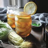 Gerösteter Maistee mit Ahornsirup      Zutaten:  4 Maiskolben, ungeschält  2 EL Ahornsirup  1 Zitrone, in dünne Scheiben geschnitten zum Garnieren  1 Jalapeño, ohne Samen und in Scheiben geschnitten zum Garnieren      Zubereitung:  1. Den Backofen auf 180 °C (Ober-/Unterhitze) vorheizen. Die Schale von den Maiskolben entfernen, aber die Maisfäden aufheben. Die Maiskörner mit den Fingern oder einem Löffel von den Kolben schaben. Das nimmt die meiste Zeit in Anspruch. Dann die Maiskörner, Maisfäden und die Kolben in einer Lage auf ein großes Backblech legen.  2. Das Blech in den heißen Ofen schieben und 1 1⁄2 Stunden backen. Jetzt die Maisfäden entfernen und beiseitestellen. Das Backblech wieder in den Ofen schieben und weitere 2 1⁄2 Stunden backen, bis die Maiskörner und -kolben vollständig getrocknet sind.  3. Die Maiskörner in eine große Gusseisenpfanne oder einen Schmortopf füllen, den Ahornsirup hinzufügen und bei mittlerer Hitze unter die Maiskörner rühren, bis sie gleichmäßig damit überzogen sind. Die Maiskörner etwa 10 Minuten garen, bis sie einen dunkelbraunen Farbton annehmen. Dabei darauf achten, dass sie nicht verbrennen.  4. Maiskolben und -fäden gemeinsam mit 2 l Wasser in die Pfanne geben. Das Wasser aufkochen lassen, die Hitze reduzieren und das Wasser etwa 15 Minuten köcheln lassen, bis es eine tiefbraune Farbe annimmt.  5. Ein Sieb auf einen Krug setzen und den Pfanneninhalt durch das Sieb gießen (die festen Stoffe entsorgen). Den Tee im Kühlschrank auf- bewahren, mit Eis servieren und mit Zitronenscheiben sowie frischer Jalapeño garnieren.