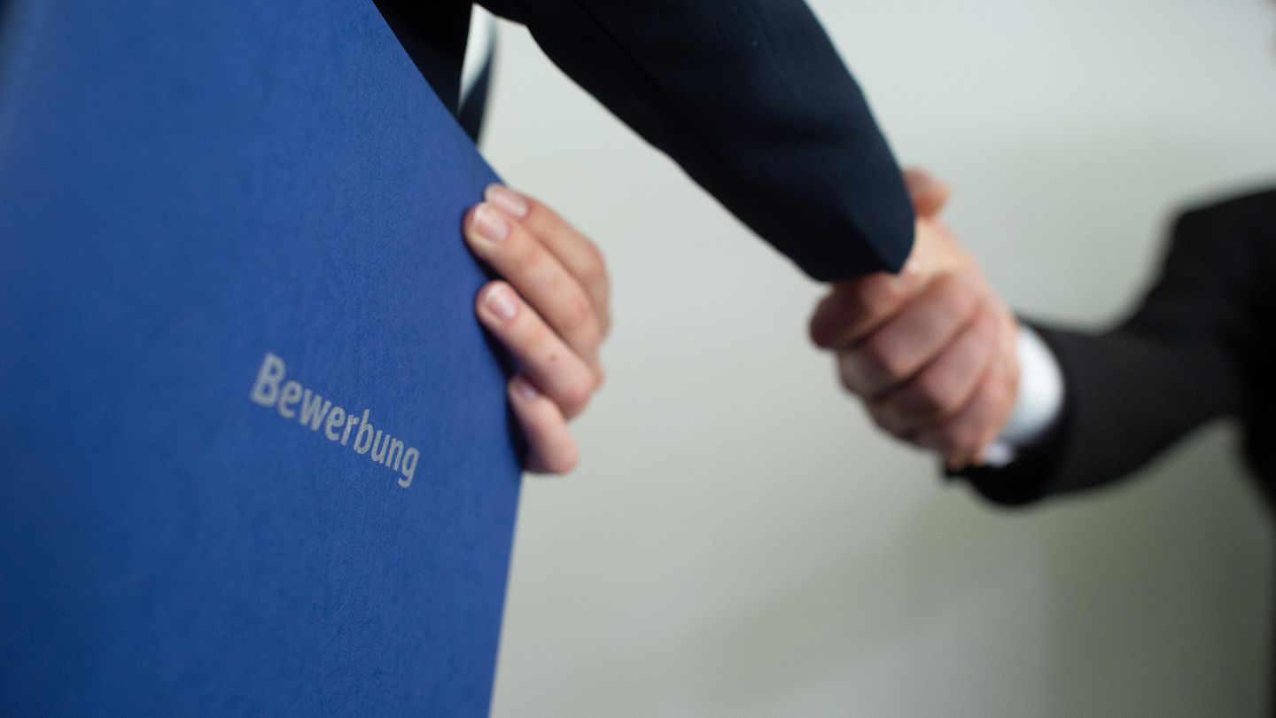 Krise: Ein Personaler und eine Bewerberin geben sich die Hand, die Bewerberin hält eine Bewerbungsmappe in der Hand