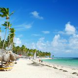Ein Strand mit türkisblauem Wasser und Sonnenliegen.