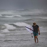 Unverdrossen geht dieser Surfer am Strand von Cocoa Beach entlang. Hurrikan "Ian" bringt natürlich auch ungewöhnlich starke Wellen mir sich