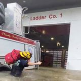 In Naples kämpft sich ein Feuerwehrmann mit geschulterter Ausrüstung durchs Wasser zur Feuerwache vor