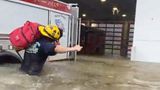 In Naples kämpft sich ein Feuerwehrmann mit geschulterter Ausrüstung durchs Wasser zur Feuerwache vor