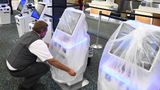 Delta-Airlines-Mitarbeiter Juan Martinez deckt einen Check-in-Terminal am Orlando International Airport mit einer schützenden Plastiktüte ab, denn der Flughafen schließt wegen "Ian"