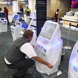 Delta-Airlines-Mitarbeiter Juan Martinez deckt einen Check-in-Terminal am Orlando International Airport mit einer schützenden Plastiktüte ab, denn der Flughafen schließt wegen "Ian"